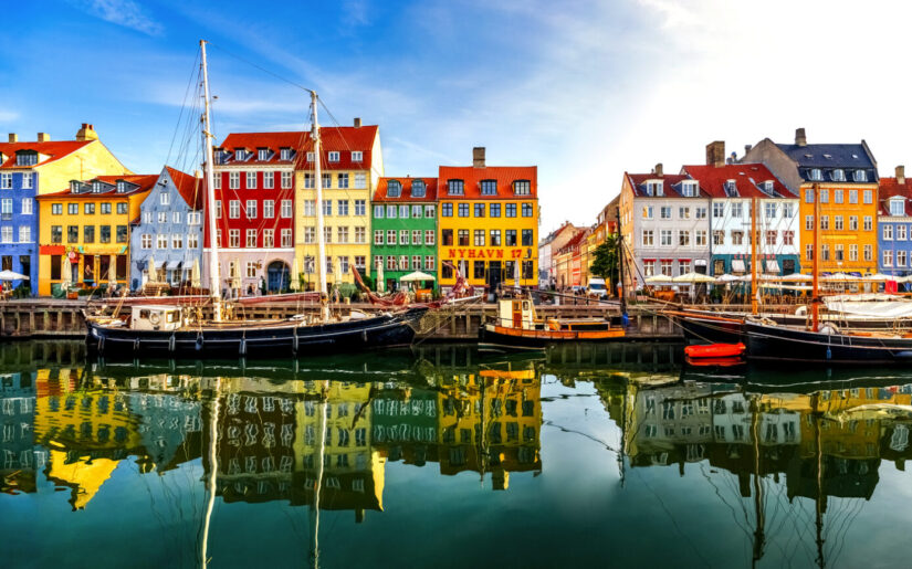 Bunte Hafenhäuser im Nyhavn von Kopenhagen spiegeln sich malerisch im ruhigen Wasser – ein Wahrzeichen Dänemarks