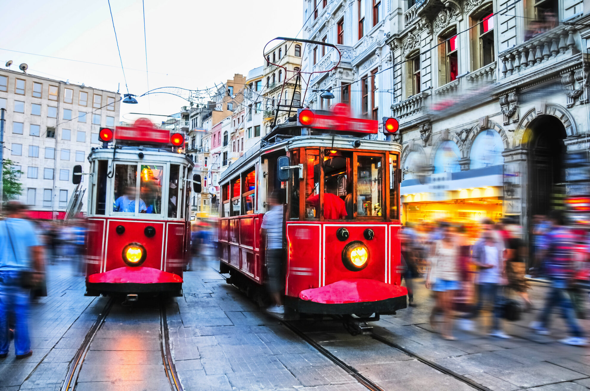 Historische rote Straßenbahnen auf der belebten Istiklal Caddesi in Istanbul – ein Wahrzeichen der Stadt, das Tradition und Moderne verbindet. Die nostalgischen Tramfahrten sind ein Highlight für Besucher und bieten authentisches Flair im Herzen der türkischen Metropole.