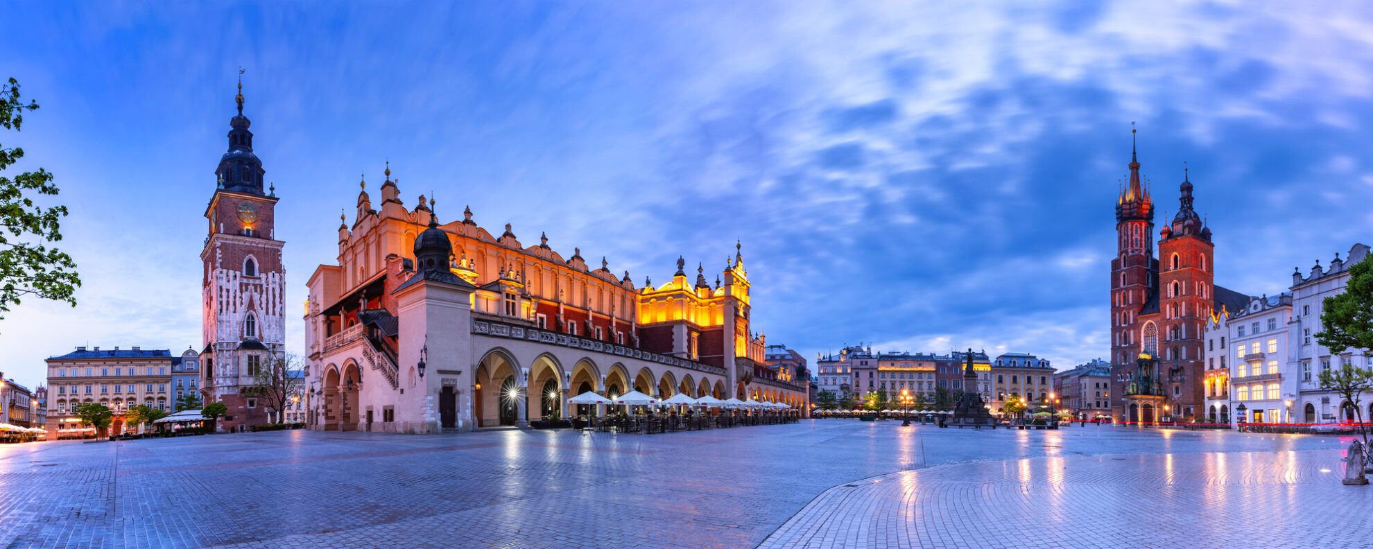 Marktplatz von Krakau in Polen – Tuchhallen, Rathausturm und Marienkirche im Abendlicht.