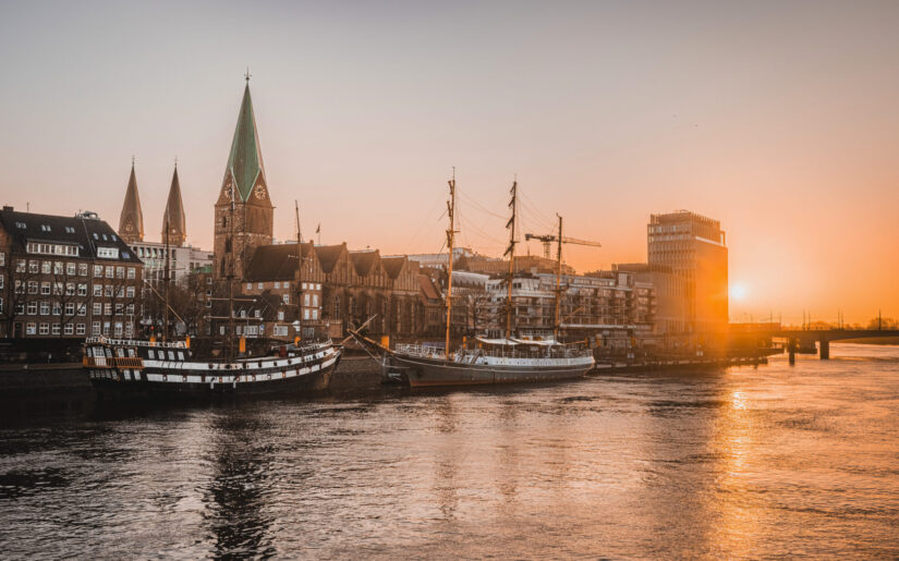 Sonnenuntergang an der Weser in Bremen – historische Schiffe und Altstadtflair im warmen Abendlicht.