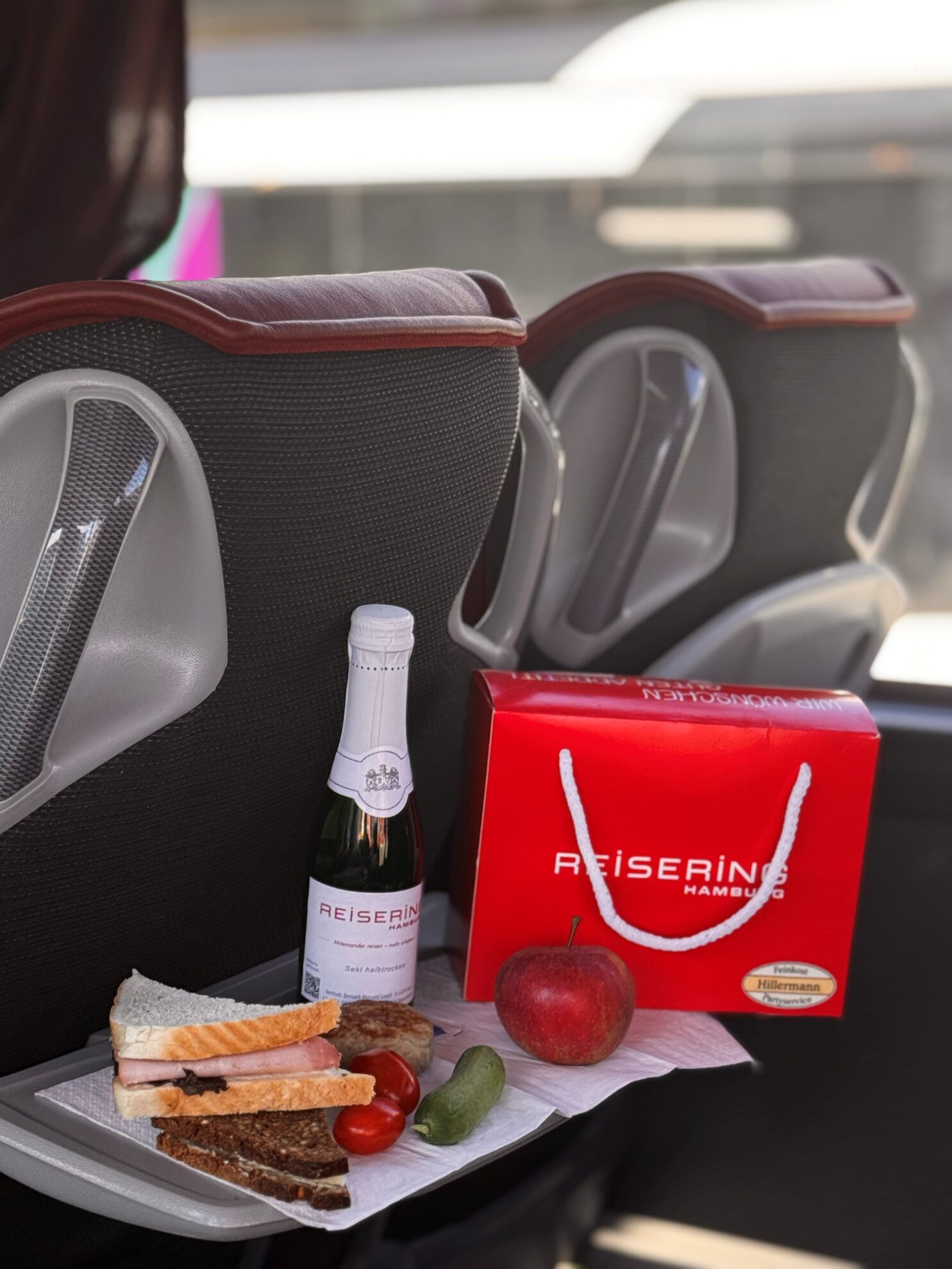 Reisegenuss im Komfortbus – Lunchpaket vom Reisering Hamburg mit frischen Snacks, Sekt und Obst für eine entspannte Busreise.