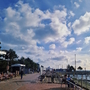 Promenade mit Sitzbänken und Wolken am Strand von Damp.