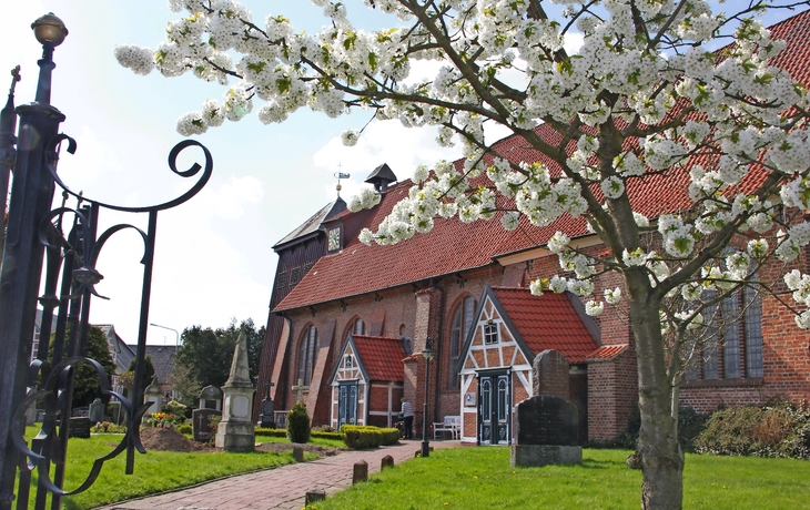Küstenstadt mit bunten Häusern und blauem Meer im Hintergrund.