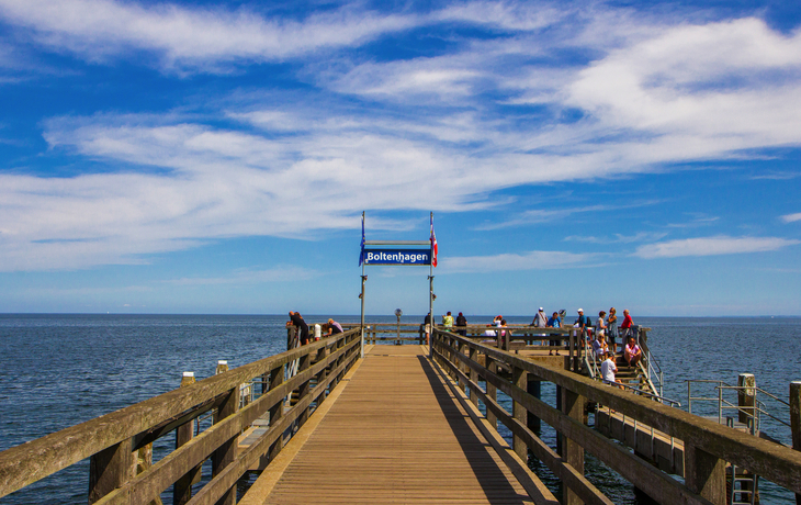 Holzsteg in die Ostsee mit Menschen und blauem Himmel in Boltenhagen.