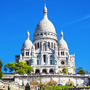 Basilika Sacré-Cœur vor blauem Himmel in Paris.