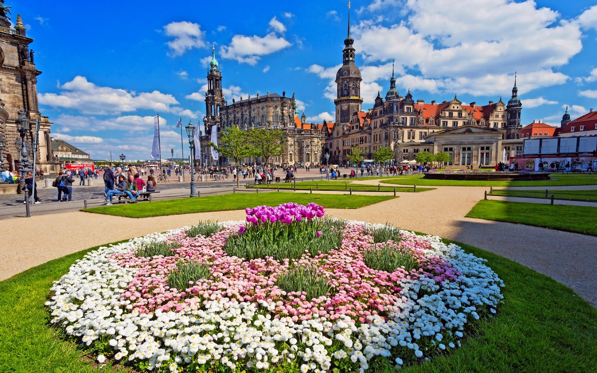 Blumenbeet im Park vor historischer Architektur bei sonnigem Wetter
