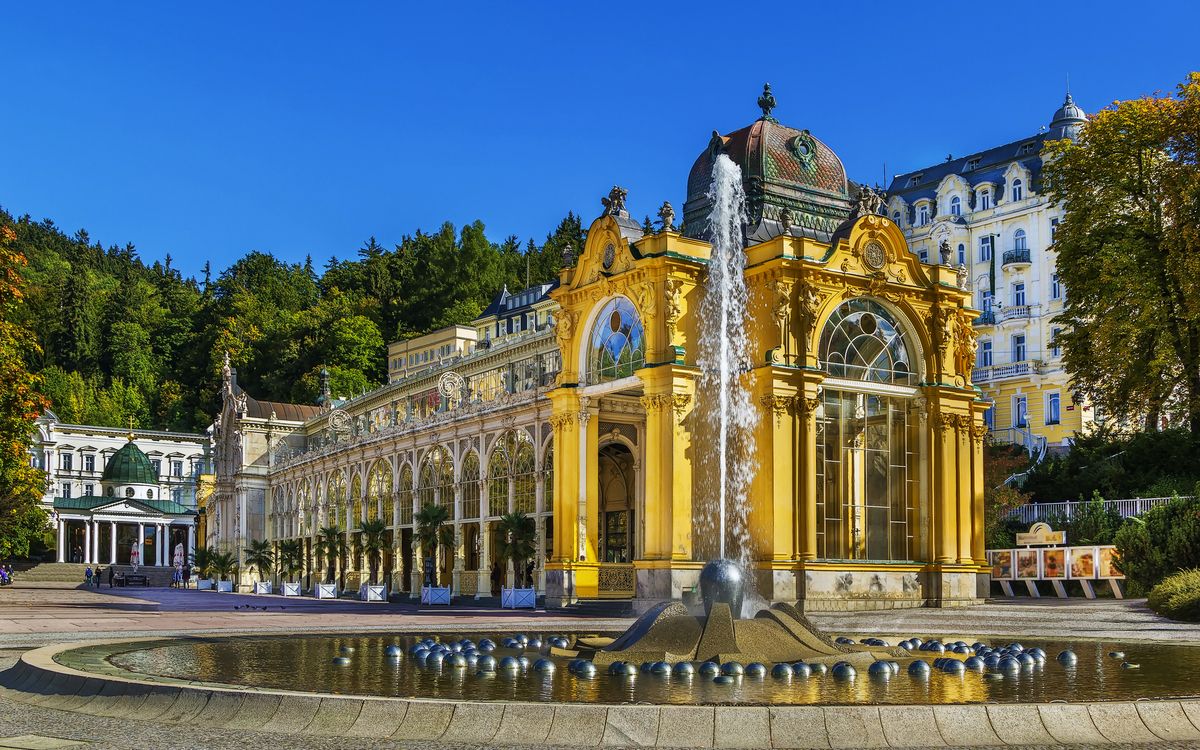 Kurhausgebäude mit Springbrunnen im Vordergrund und blauem Himmel im Hintergrund.