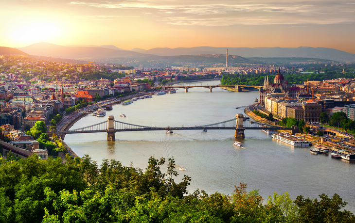 Panoramablick auf Budapest mit der Donau und Brücken im Sonnenuntergang.