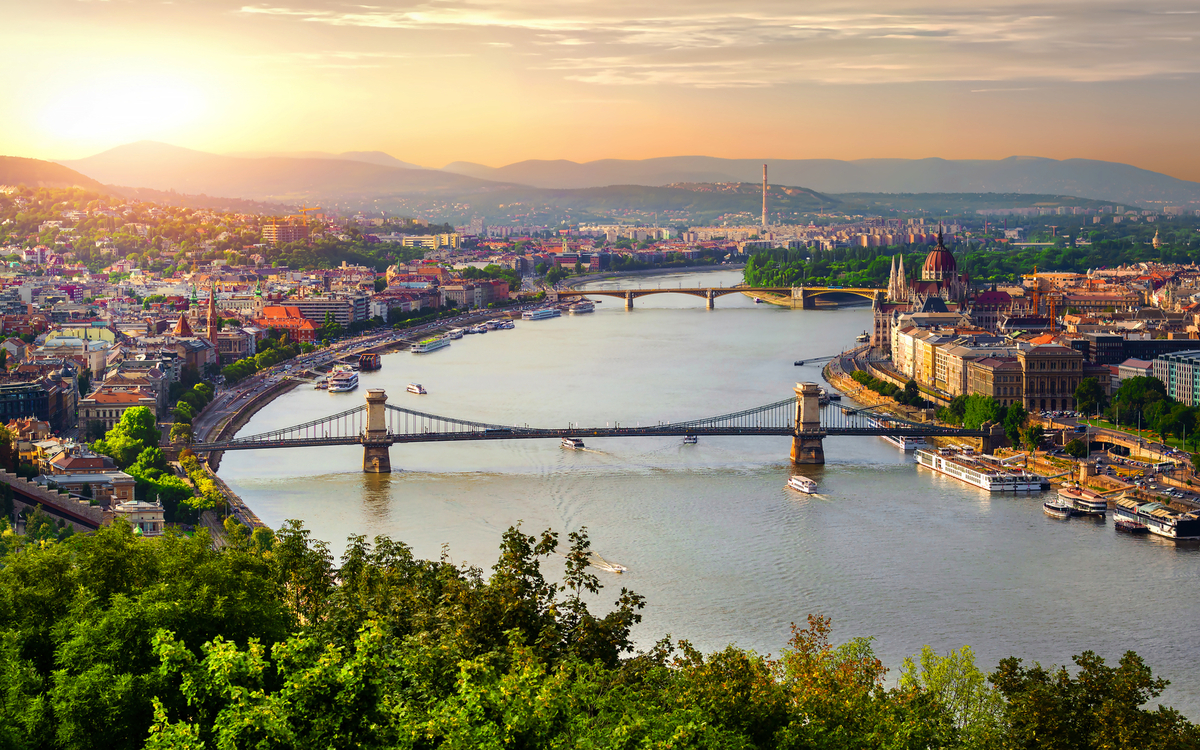 Panoramablick auf Budapest mit der Donau und Brücken im Sonnenuntergang.