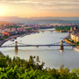 Panoramablick auf Budapest mit der Donau und Brücken im Sonnenuntergang.
