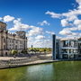 Panorama des Berliner Regierungsviertels mit Reichstag und Spree bei Sonnenschein.
