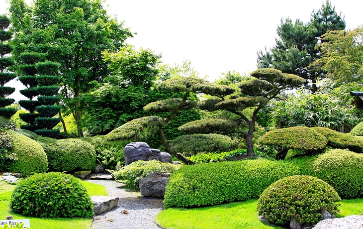 Barockbrunnen in Stadtplatz mit großen Skulpturen und umgebenden Gebäuden.