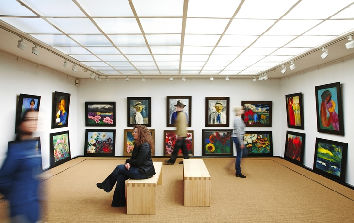 Malerisches Küstendorf mit bunten Häusern und Hügeln im Hintergrund.