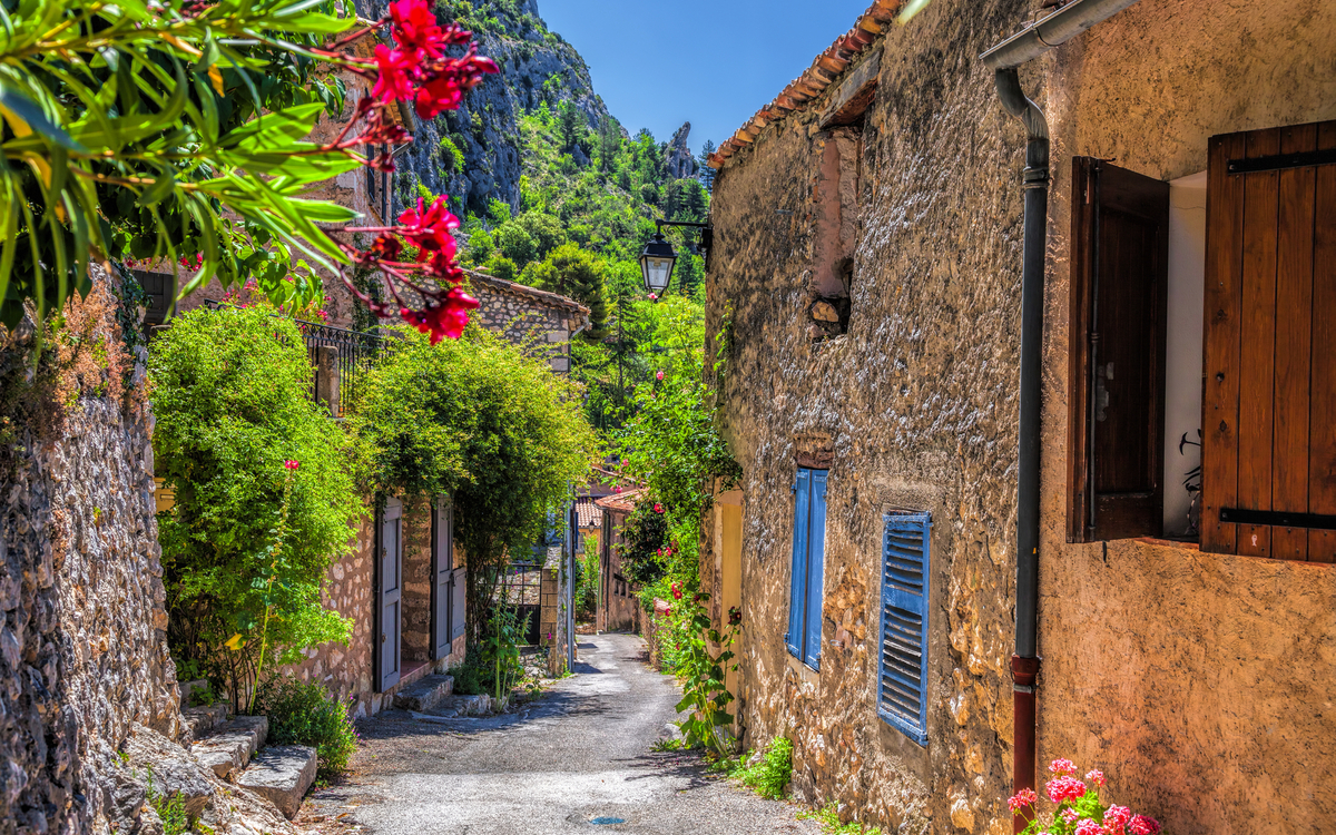 Malerische Gasse in einem alten europäischen Dorf mit blühenden Pflanzen.