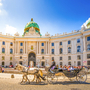 Die Hofburg in Wien mit einer Pferdekutsche auf dem Heldenplatz.