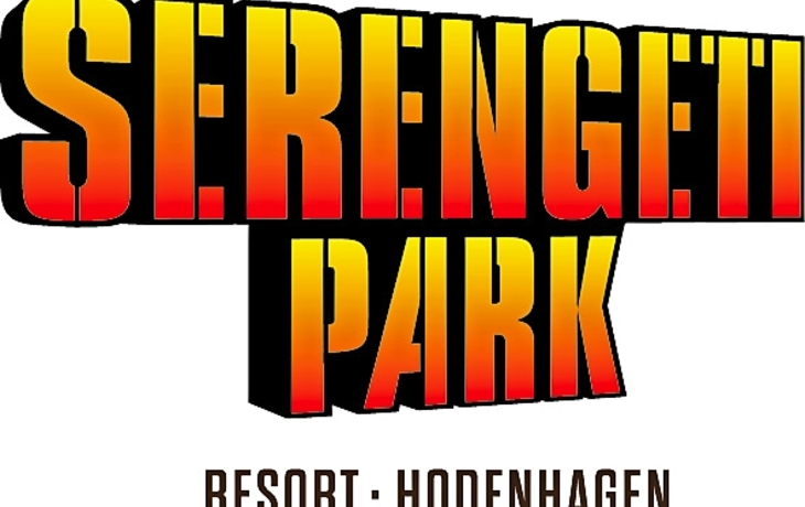 Fachwerkhaus mit bunten Fensterläden und Blumen auf einer gepflasterten Straße.