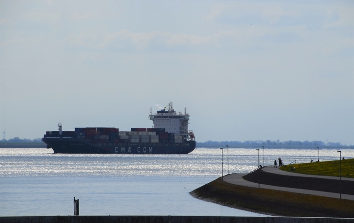Historische Brücke mit bunten Gebäuden und Fluss unter blauem Himmel.