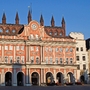 Historisches Gebäude mit Uhr und verziertem Dach im Abendlicht.