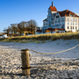 Strand mit Dünen und historischer Gebäudekulisse bei blauem Himmel