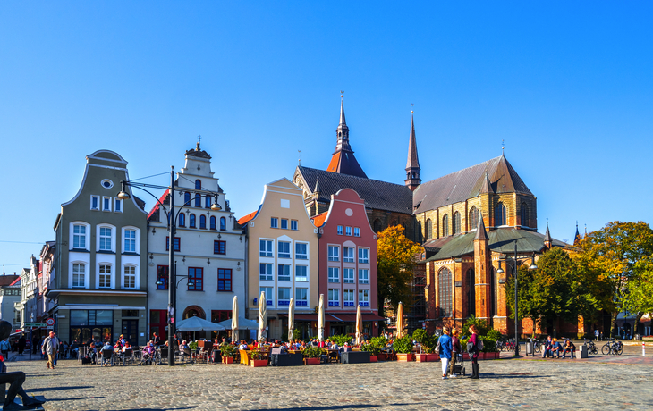 Historische Gebäude und Kirche an einem sonnigen Platz.