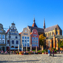 Historische Gebäude und Kirche an einem sonnigen Platz.