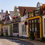 Reihe bunter, traditioneller Häuser mit Blumen in der Sonne.