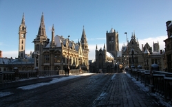Eine verschneite Altstadt mit gotischen Gebäuden bei klarem Himmel.