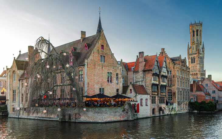 Historische Gebäude und Kanal mit Baum, Stadtpanorama bei Dämmerung.