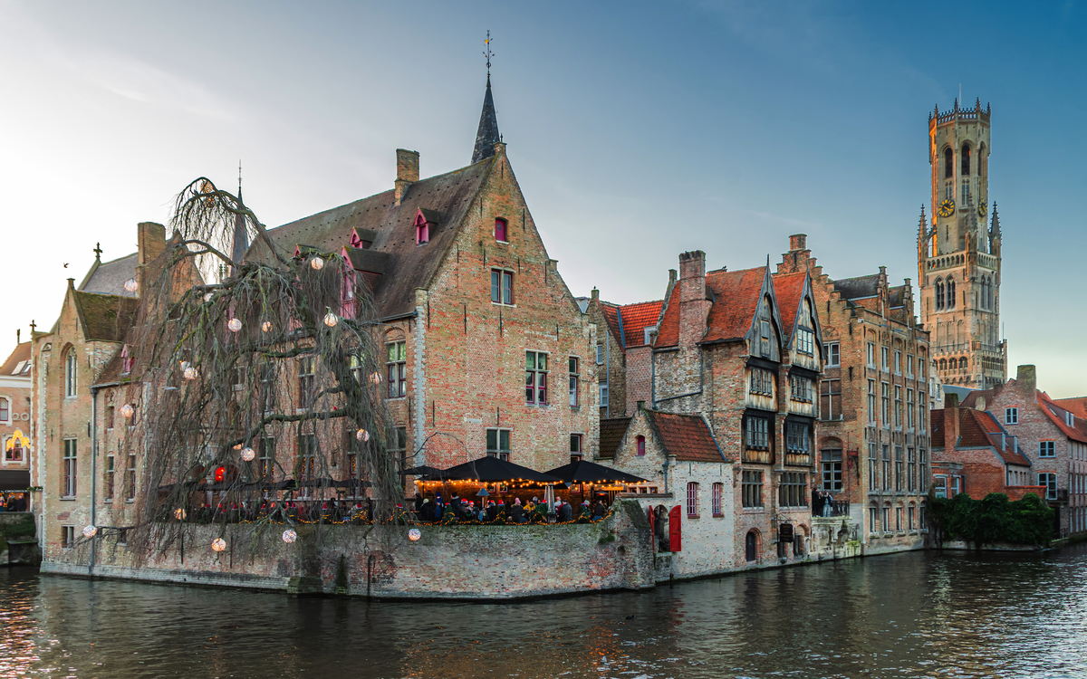 Historische Gebäude und Kanal mit Baum, Stadtpanorama bei Dämmerung.
