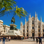 Palme, Reiterstatue und gotische Kathedrale auf einem belebten Platz.