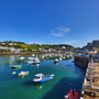 Boote im Hafen mit Burg im Hintergrund bei blauem Himmel