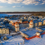 Kurhaus von Binz im Winter, umgeben von schneebedeckten Gebäuden und der gefrorenen Ostsee.