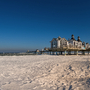 Seebrücke an einem sonnigen Tag mit klarem Himmel und Strand.