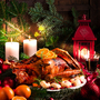 Festlich gedeckter Tisch mit gebratenem Truthahn, Kerzen und Weihnachtsschmuck.
