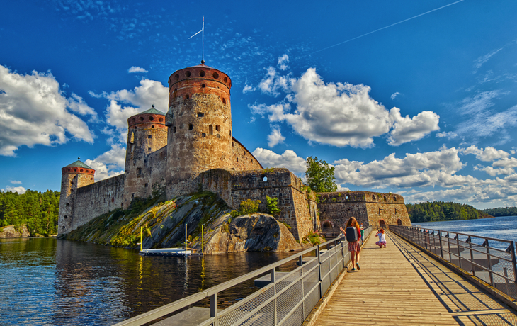 Mittelalterliche Burg mit Türmen am Wasser bei sonnigem Wetter. Olofsborg, Savonlinna