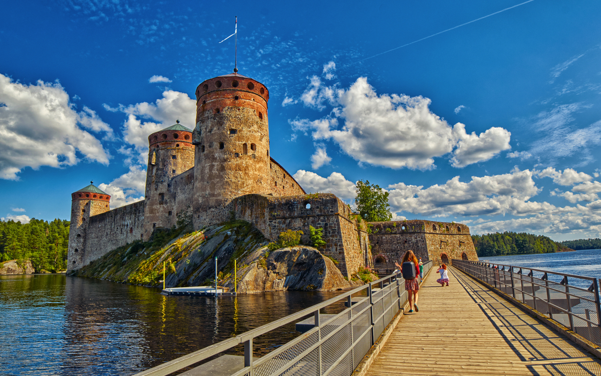 Mittelalterliche Burg mit Türmen am Wasser bei sonnigem Wetter. Olofsborg, Savonlinna