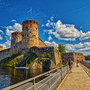 Mittelalterliche Burg mit Türmen am Wasser bei sonnigem Wetter. Olofsborg, Savonlinna