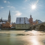 Verschneite Altstadt mit Dom und Brücke im Sonnenlicht. Regensburg