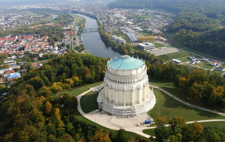 Luftaufnahme eines runden Denkmals in einer Landschaft mit Fluss und Stadt.