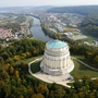 Luftaufnahme eines runden Denkmals in einer Landschaft mit Fluss und Stadt.