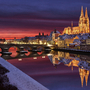 Regensburg bei Sonnenuntergang mit Dom und Steinerner Brücke, Spiegelung im Fluss. Regensburg