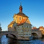 Historisches Rathaus auf einer Brücke über einem Fluss an einem klaren Tag.