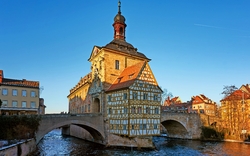Historisches Rathaus auf einer Brücke über einem Fluss an einem klaren Tag.