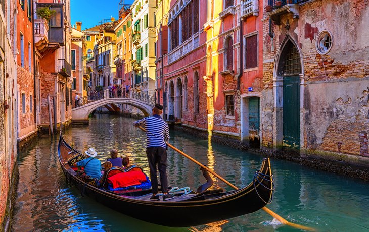 Gondel in Venedig auf einem Kanal vor bunten Häusern.