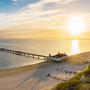 Sonnenaufgang am Ahlbecker Strand mit Blick auf die Seebrücke in Heringsdorf, Mecklenburg-Vorpommern, Deutschland.