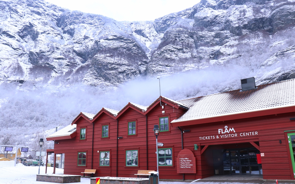 Rotes Besucherzentrum in schneebedeckter Berglandschaft.