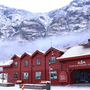 Rotes Besucherzentrum in schneebedeckter Berglandschaft.