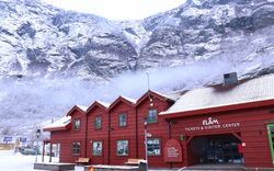 Rotes Besucherzentrum in schneebedeckter Berglandschaft.