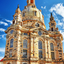 Eine barocke Kirche mit großer Kuppel und reich verzierten Fassaden unter einem blauen Himmel.