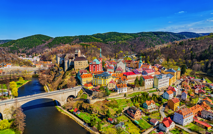 Loket Luftaufnahme einer bunten Kleinstadt mit Brücke und Fluss in einer hügeligen Landschaft.
